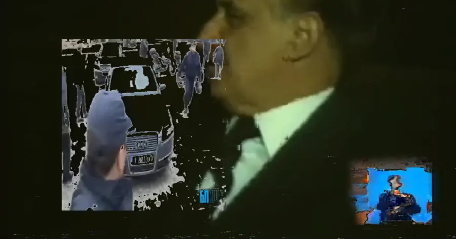 Кадър от видео инсталацията — На кадъра се вижда видеото “Ченгета раздават колена и влачат хора пред излизащи от парламента коли”.