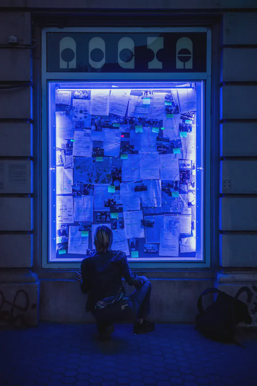Първите десет (2024) - Никола Стоянов — Нощен изглед на 'Първите десет'. Корк, дървена рамка, документи, картички, червена прежда, неонова светлина